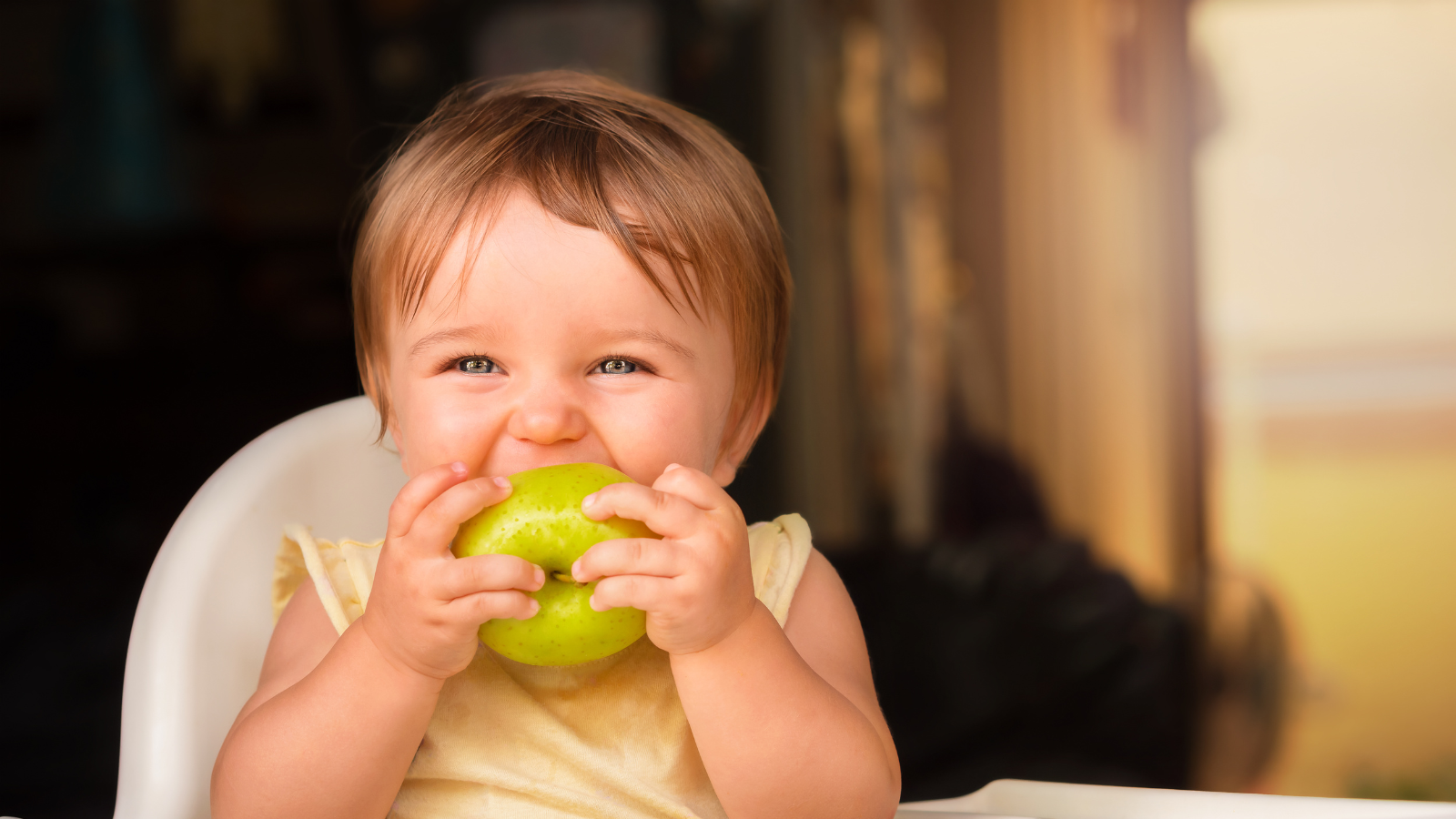 Baby taking bite of apple