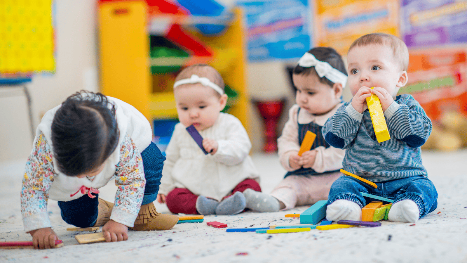 four babies sitting on the floor of a child care center